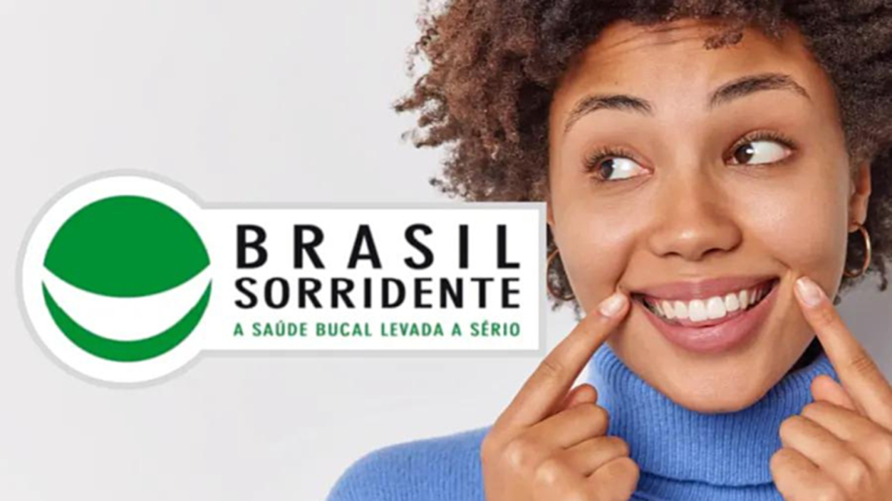 Imagem de mulher apontando para seu sorriso, está escrito "Brasil sorridente, a saúde bucal levada a sério".