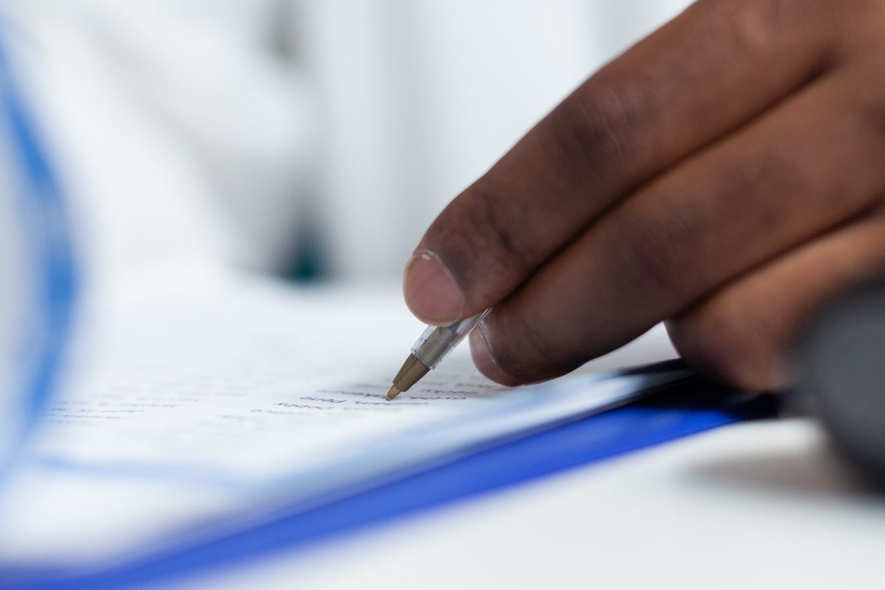 Mão de doutor escrevendo receita.