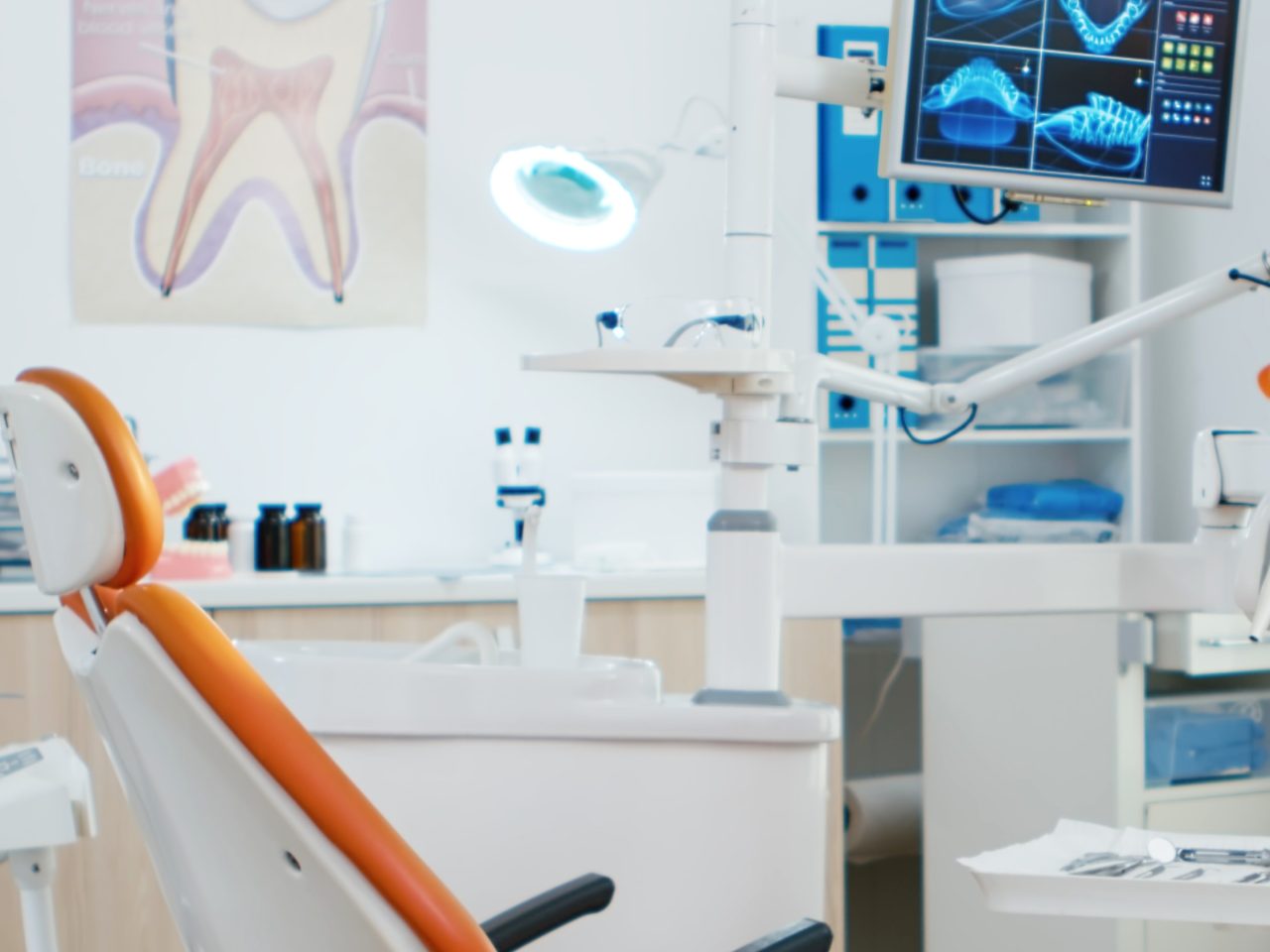 Consultório odontológico com pôster de dente na parede.
