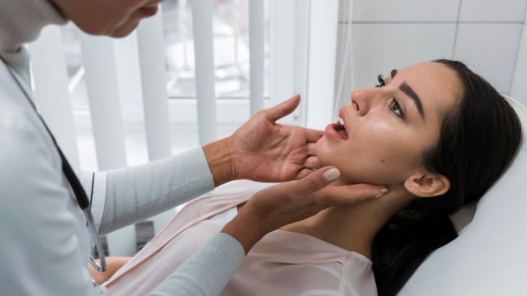 Dentista avaliando mandíbula de paciente.