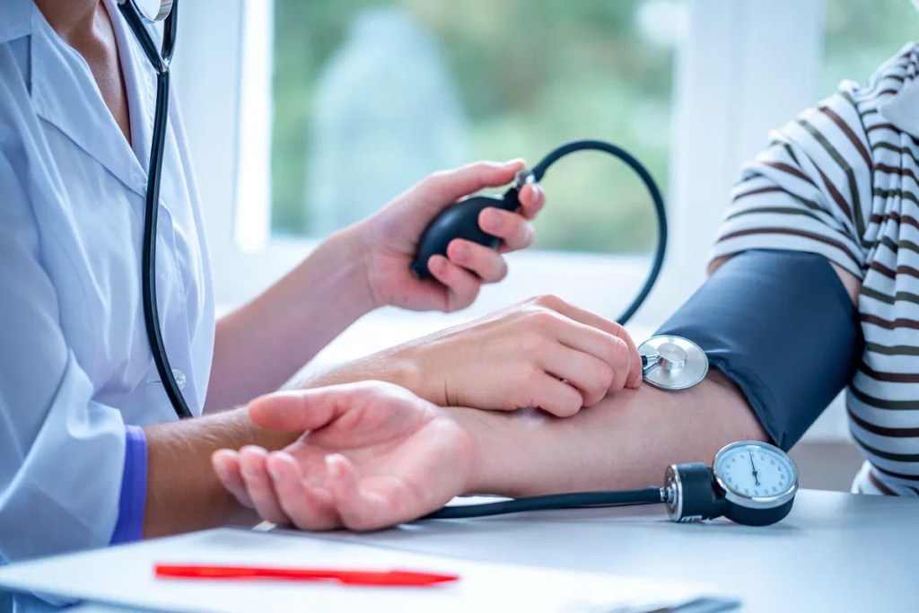Médica aferindo pressão de paciente.