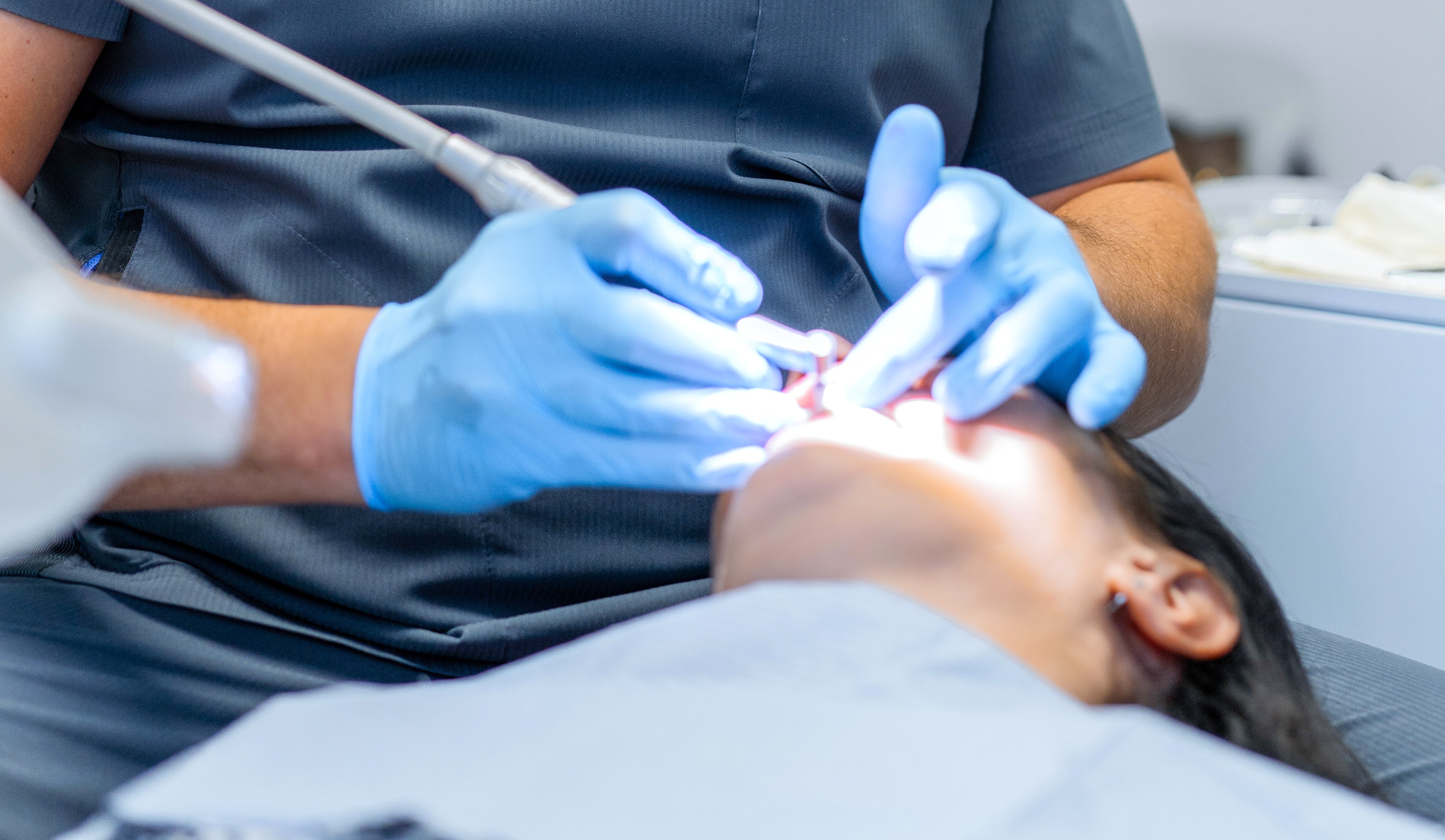 Dentista realizando tratamento dentário em paciente.