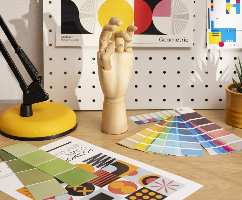 Mesa com diversas paletas de cores, e outras ferramentas para definir o branding da marca.