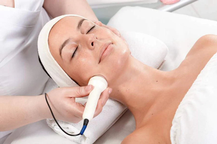 Realizando radiofrequência facial em paciente mulher.