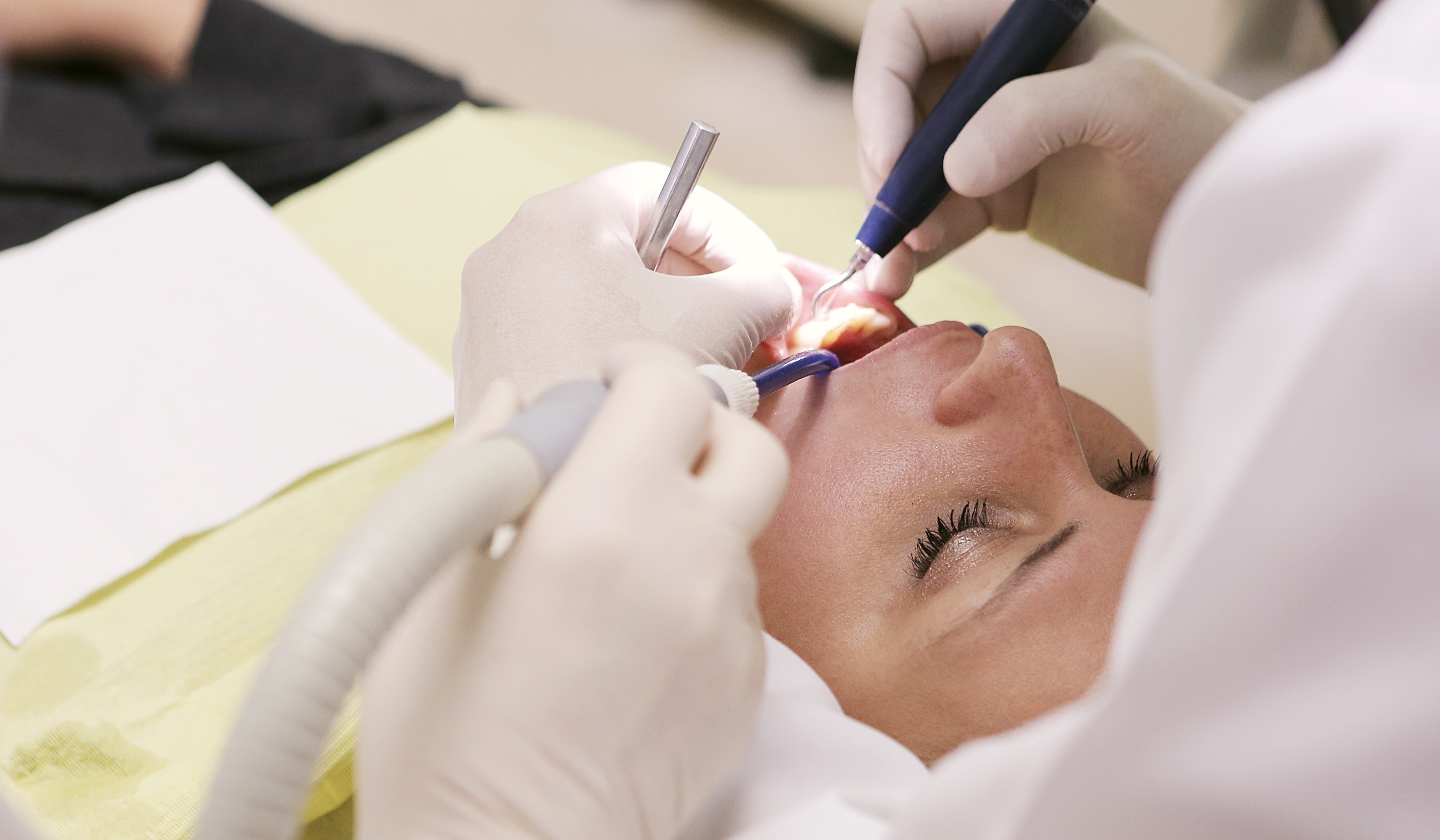 Dentistas fazendo cirurgia em paciente.
