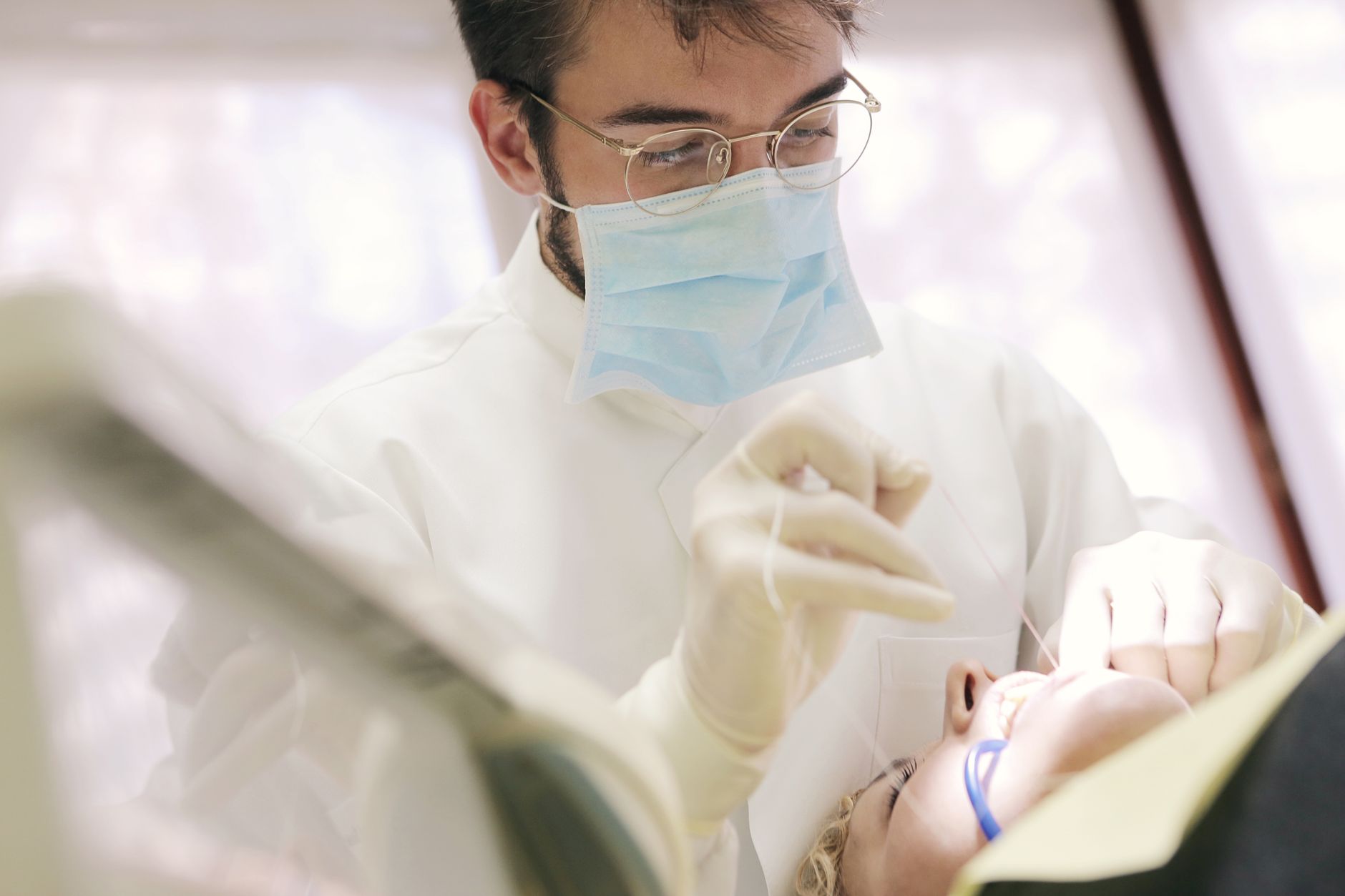 Close-up of a dentist in a face mask working on a patient's dental care.